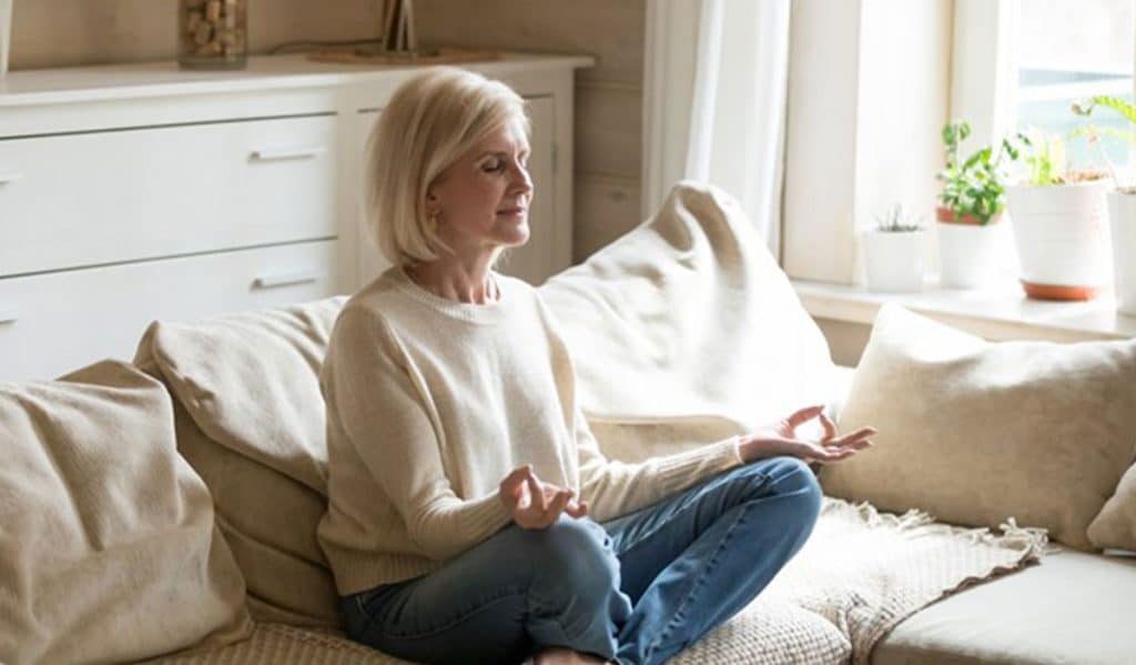 woman meditating on living room